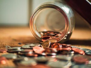 coins spilling out of a jar - The cost of being in a car accident